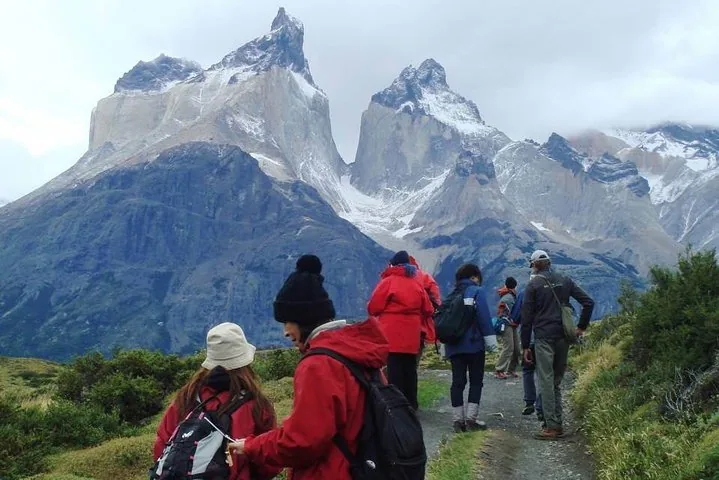 Gruppo di persone che cammina su un sentiero verso montagne maestose